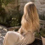 A model with blonde hair in a fashionable setting.