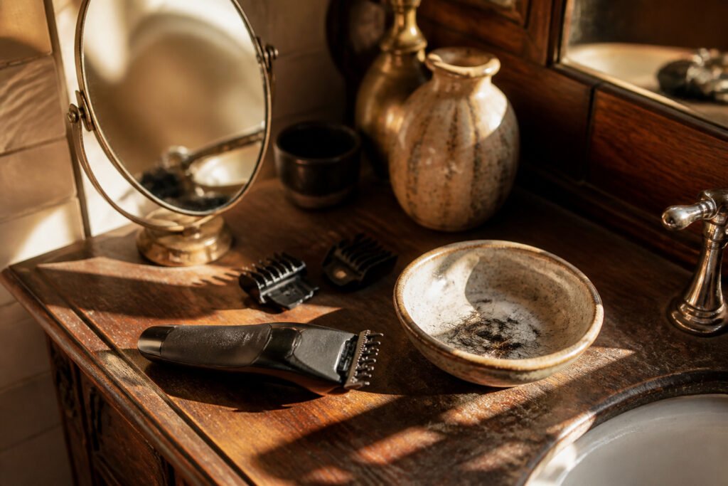 A man looking into a mirror while grooming his sideburns.